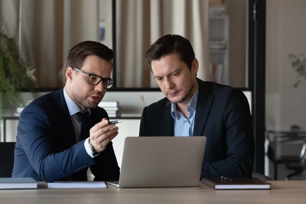 business man helping someone on a laptop